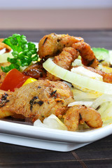 A meal of grilled meat and mixed salad on a plate