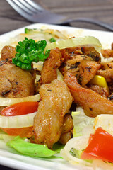 A meal of grilled meat and mixed salad on a plate
