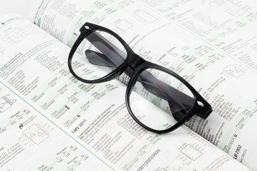 Black framed glasses put on the book