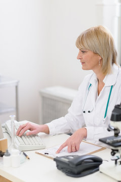 Middle age doctor woman working on computer