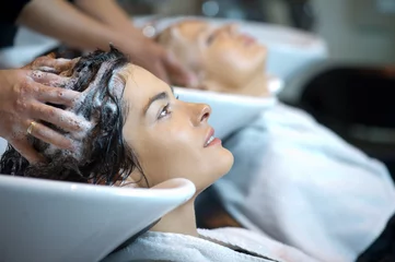 Crédence de cuisine en verre imprimé Salon de coiffure Beautiful woman getting a hair wash. In a hair salon