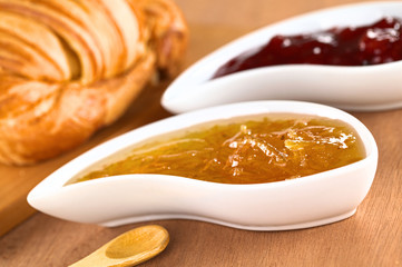 Orange and strawberry jam with croissant