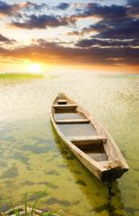 Boat at coast against asunset.