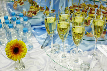 Wine, water, snacks and flower on a smorgasbord.