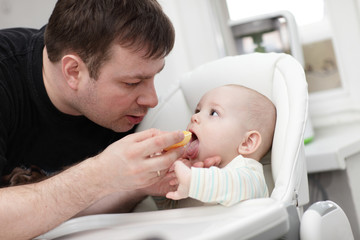Obraz na płótnie Canvas Father feeding his baby