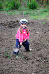 The little girl works in the garden