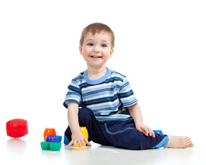Funny little child is playing with cup toys while sitting on flo