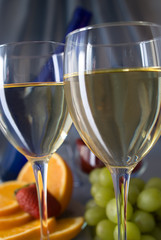 Clouseup of glasses of wine with oranges and grapes