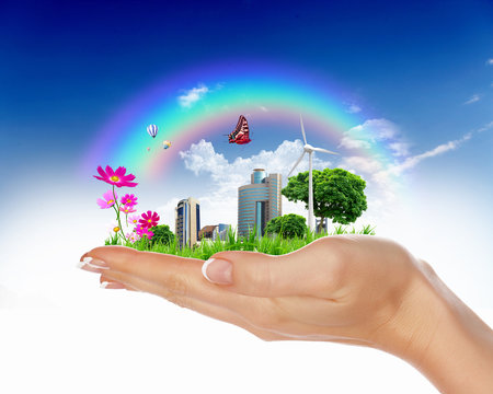 Human hand holding a green landscape