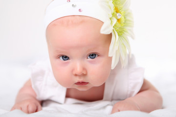 Portrait of a baby girl with a flower on her head