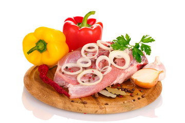 Raw meat and vegetables on a wooden board isolated on whitе