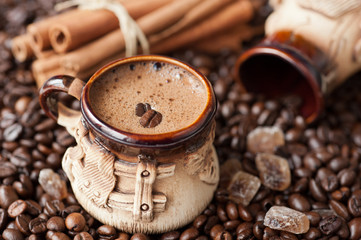 cup of coffee with coffee beans and cinnamon sticks