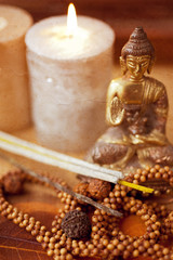 Statue of Buddha, incense, candles and rudraksha. retro style.