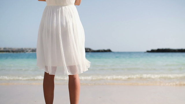Woman in white dress standing on the beach