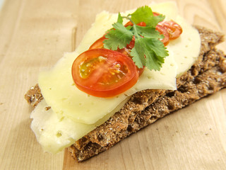 Fototapeta na wymiar Cracker with cheese, tomato and parsley