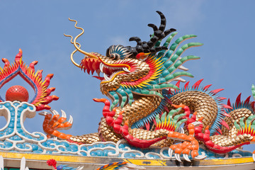 dragon Chinese statue on top of general temple roof  against blu