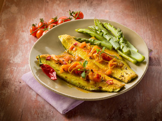 fish fillet with tomato hot chili pepper and asparagus