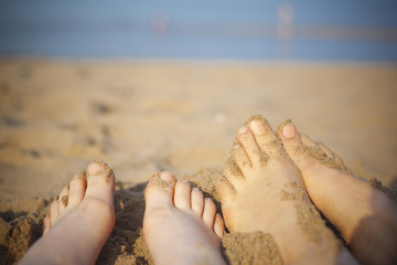 happy grils feet and warm sand of the beach