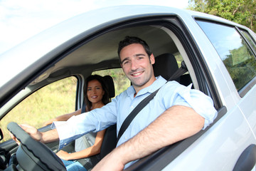 Happy couple riding car on vacation