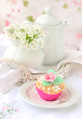 Cupcake with teapot and jug at background