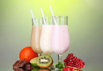 Milk shakes with fruits and chocolate on green background