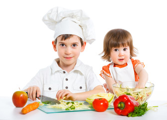 Two smiling kids mixing salad