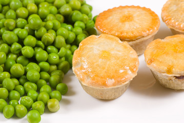 Several meat pies served with peas