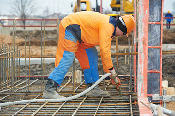 builder worker pouring concrete into form