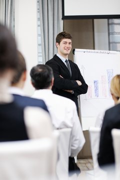 Young  business man giving a presentation on conference
