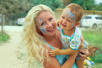 face painted happy mother and child playing outdoor