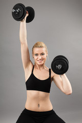 Fototapeta na wymiar Athletic young lady working out with weights