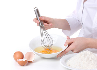 Female hands mixing eggs in bowl isolated on white