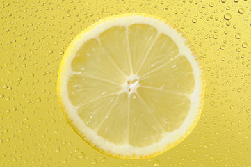 Lemon with many water drops on the yellow background