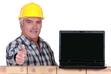 Builder giving the thumbs up to a laptop with a blank screen