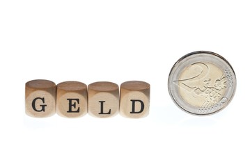 Wort "Geld" aus Buchstabenw&uuml;rfeln und Euro-M&uuml;nze, freigestellt, Freisteller