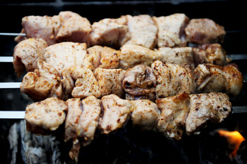 Juicy slices of meat with spices cooking on fire