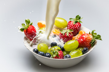 Milk pouring into dish with fresh fruits