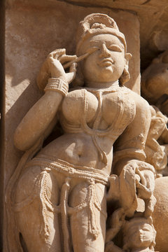 Khajuraho carving of a woman applying makeup