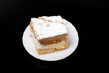 sweet  cake with cream isolated on black