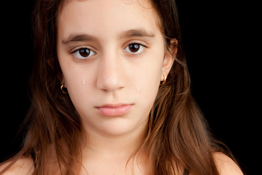 Very sad girl crying isolated on black