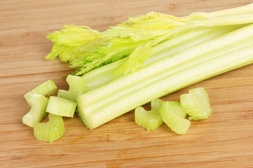 fresh slised green celery on wooden background.