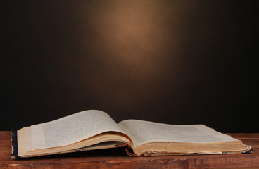 old book on wooden table on brown background