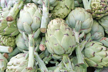 Fototapeta premium green artichokes with stems in the grocery store sales