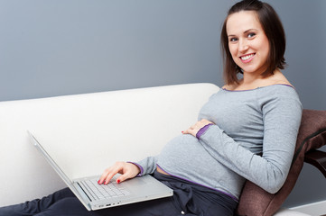 pregnant woman with laptop at home