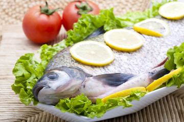 fresh fish with sliced lemonand vegetables