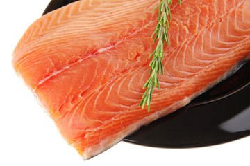 fresh raw salmon fillet on black with rosemary