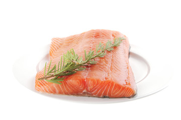 fresh uncooked salmon fillet on plate with rosemary