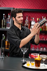 Young bartender make cocktail shaking drinks