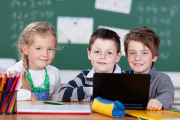 drei schulkinder arbeiten mit laptop
