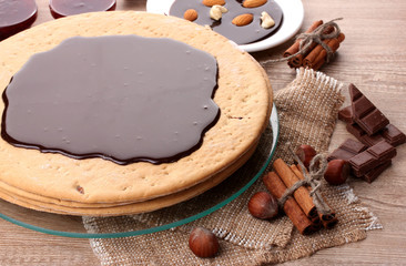 cake on glass stand and nuts on wooden  table